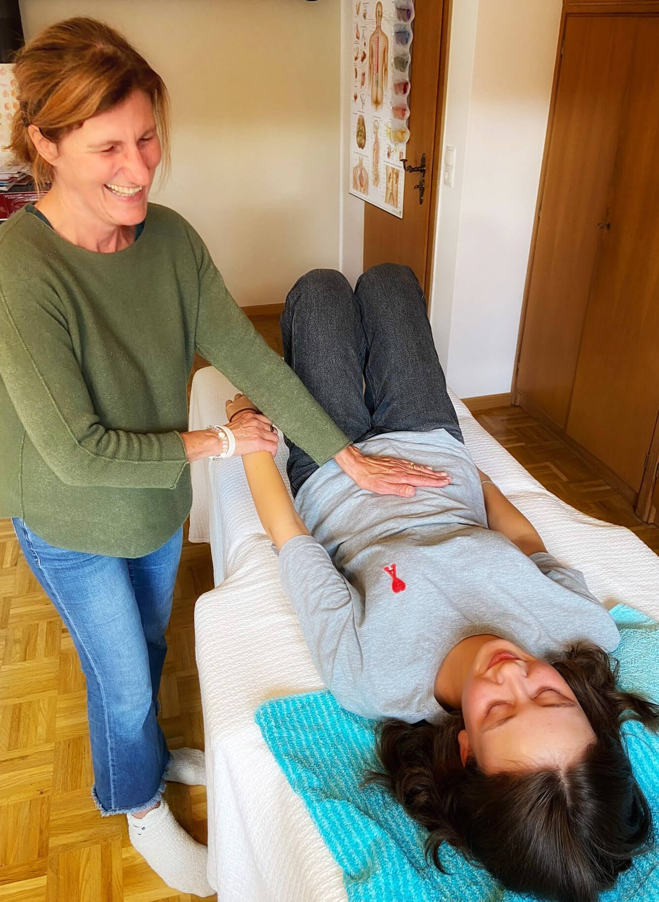 In einer Kinesiologie Behandlung, bei dem Johanna die Hand auf den Bauch eines Kindes legt, um den Muskeltest durchzuführen.